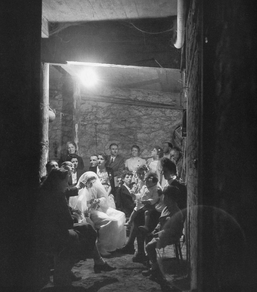 Monique Foucault's First Holy Communion in the basement of 46 place Jules Ferry, Montrouge, 1943. Robert Doisneau.